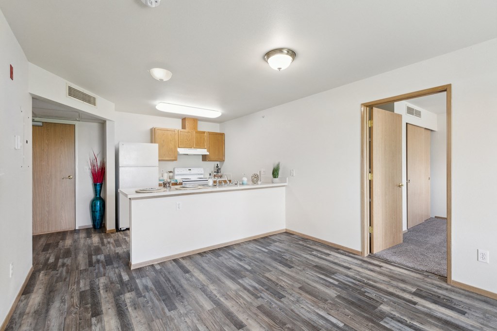 the living room and kitchen in a renovated apartment with wood flooring