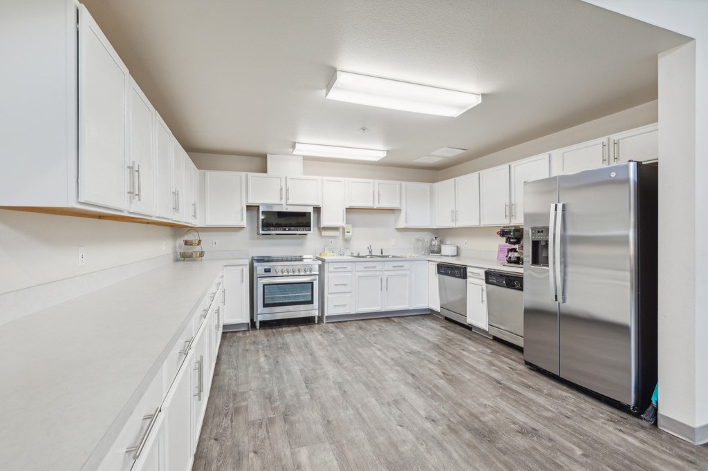 a large kitchen with white cabinets and stainless steel appliances