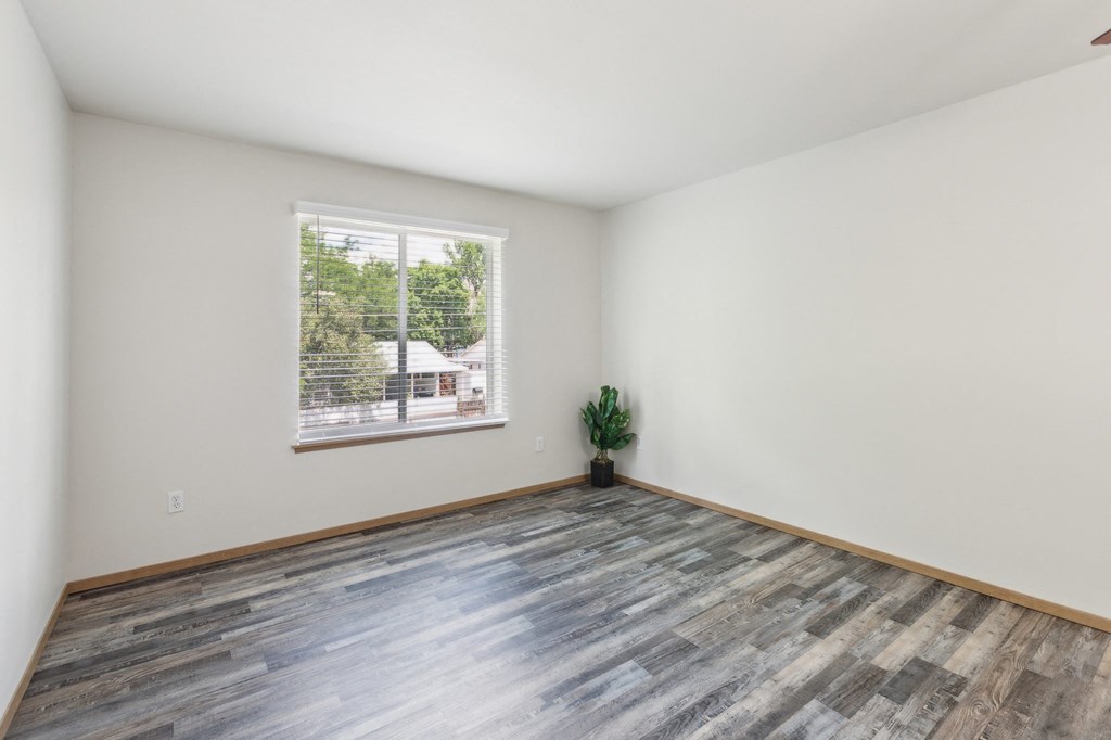 an empty room with wood floors and a window