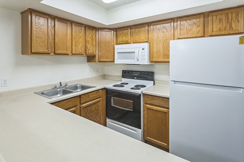 A kitchen with wooden cabinets and white appliances.