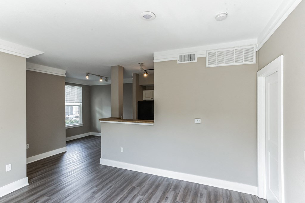 an empty living room and kitchen with wood flooring and a window at Province of Briarcliff Apartments, Kansas City, 64118