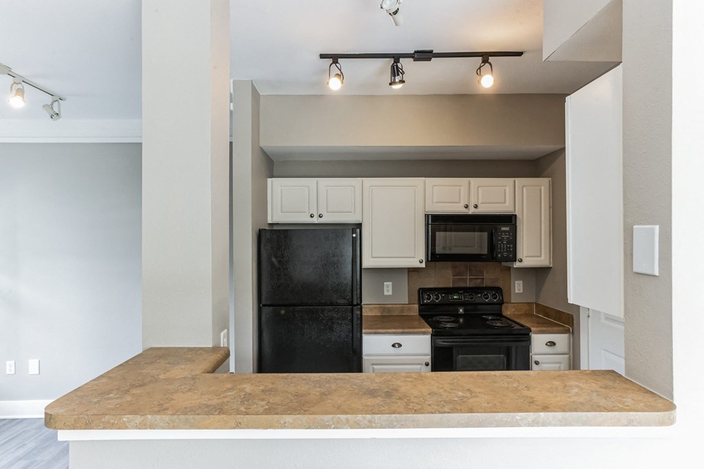 an empty kitchen with a counter top and a black refrigerator at Province of Briarcliff Apartments, Kansas City