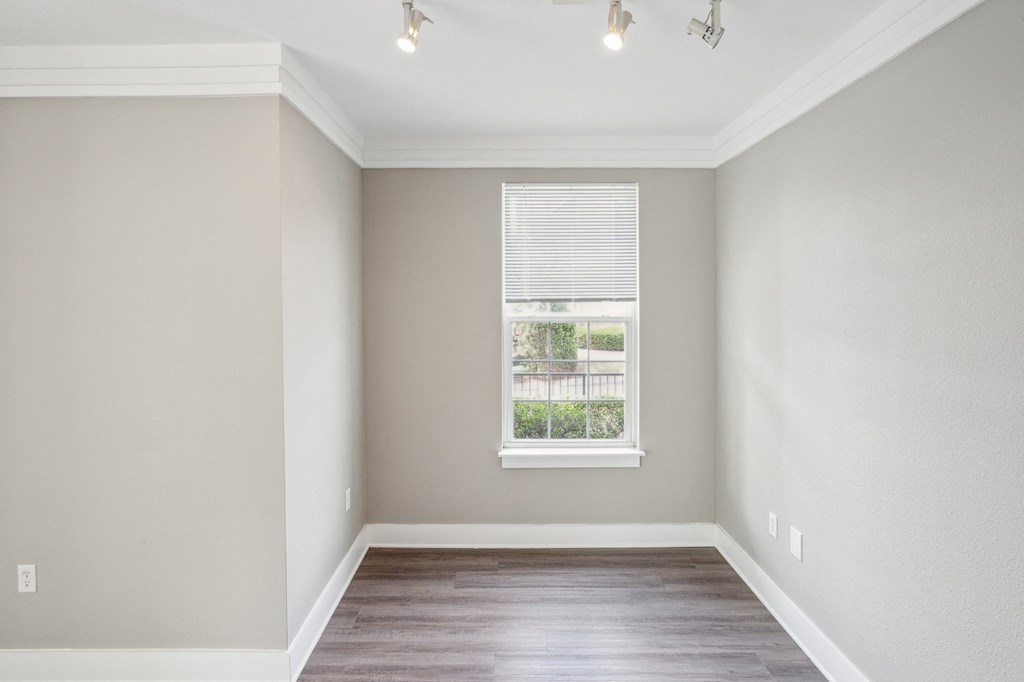 an empty room with wood floors and a window at Province of Briarcliff Apartments, Kansas City, Missouri