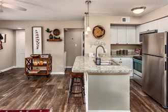 the spacious kitchen with stainless steel appliances and granite counter tops