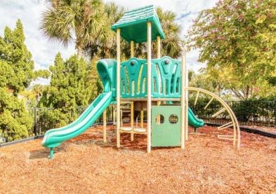 a childrens playground with a slide and a monkey bar