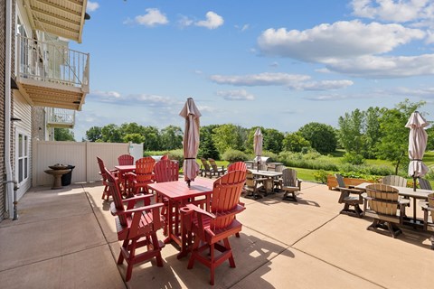 a patio with tables and chairs and umbrellas on the patio of a building