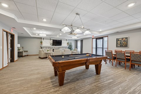 a community room with a pool table in the center