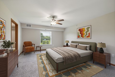A bedroom with a bed, chair, and a painting on the wall.