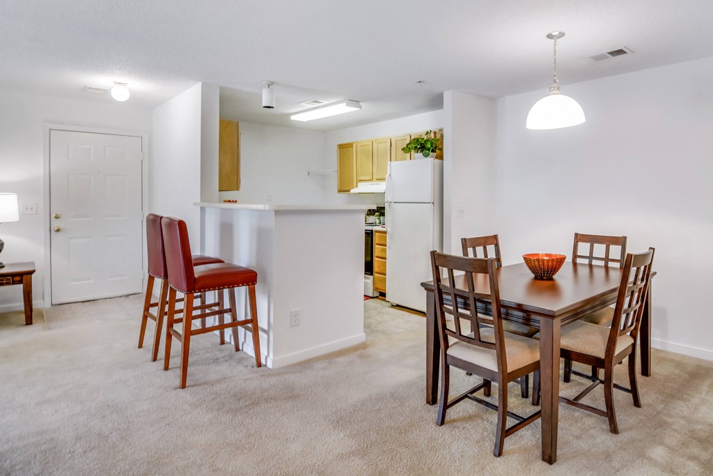 the living room and dining room of an apartment with a table and chairs