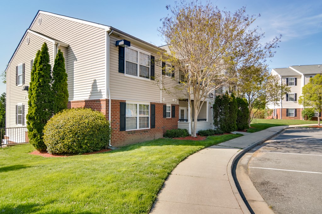 an apartment building with a sidewalk in front of it