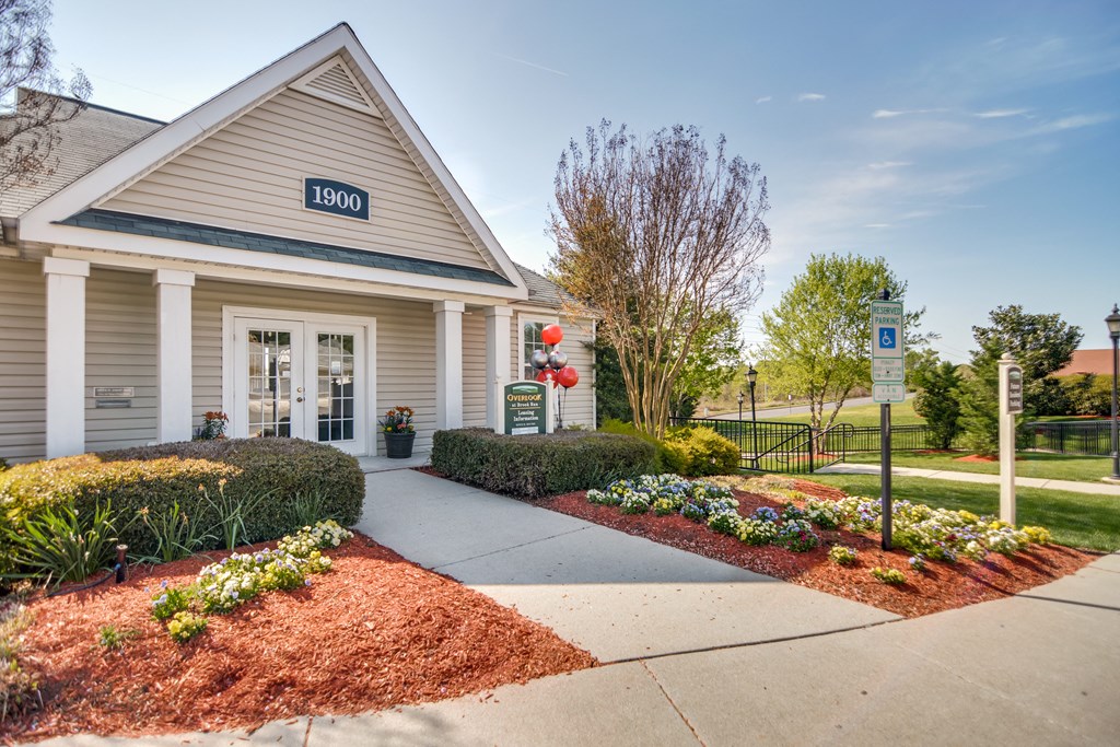 the front of the office building with a sidewalk and landscaping