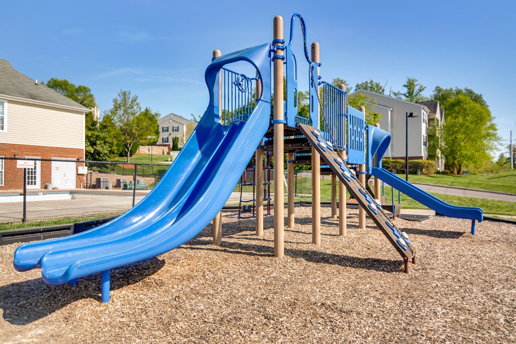 a playground with a blue slide at a park