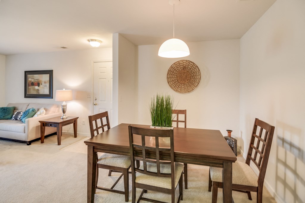 a dining room and living room with a wooden table and chairs