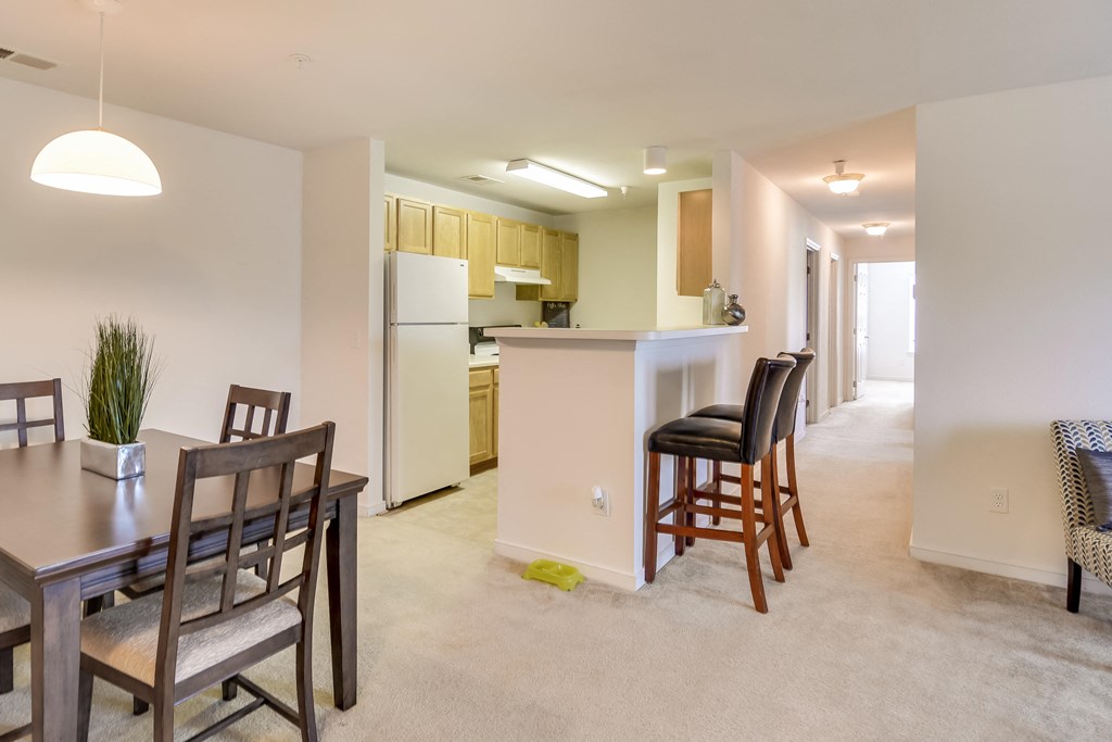 a living room and kitchen with a dining room table and chairs