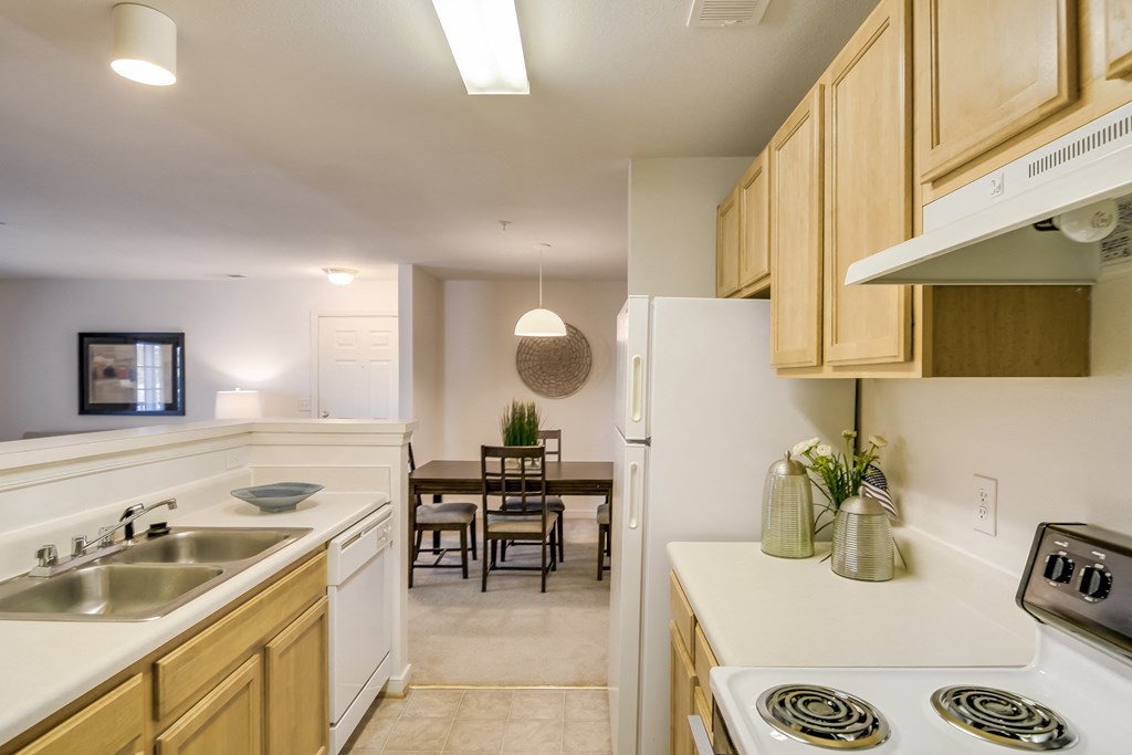 a kitchen and dining room with white appliances and wooden cabinets