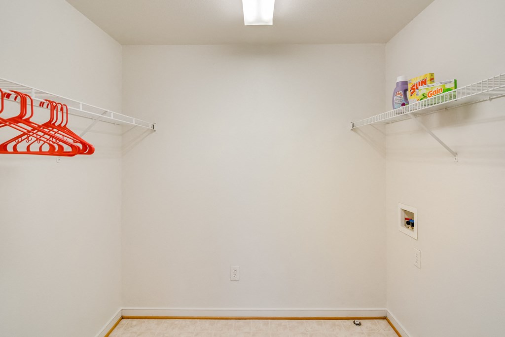 a room with white walls and shelves and a light on the ceiling
