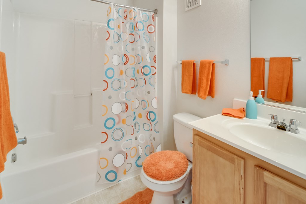 a bathroom with a shower curtain and a sink and a toilet