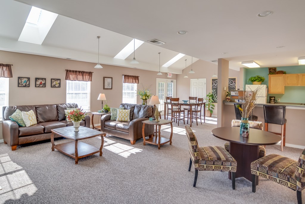 a living room with couches and chairs and a kitchen with a table