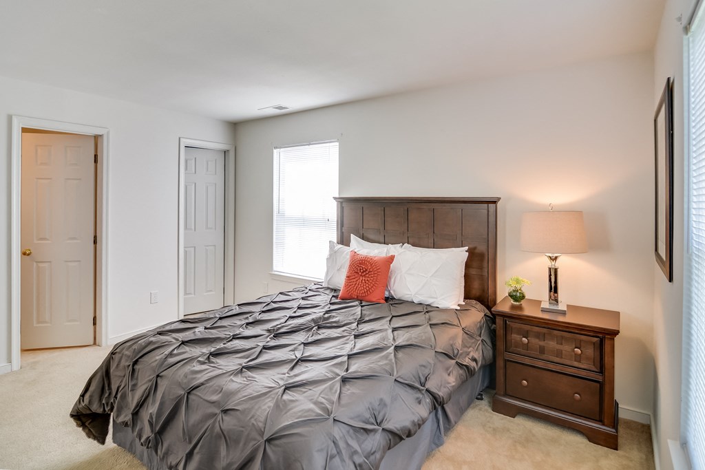 a bedroom with a bed and a dresser and a window