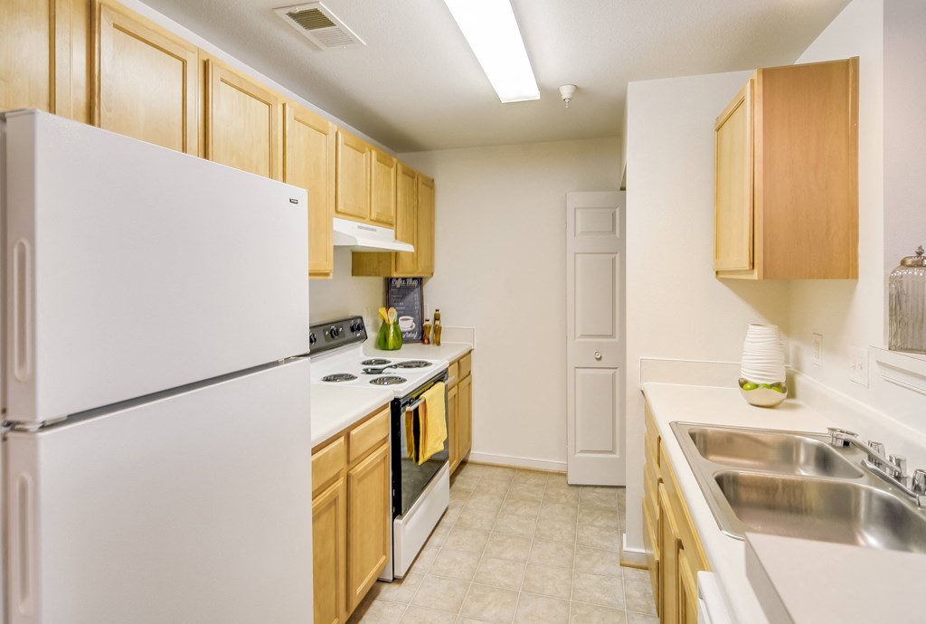 a kitchen with white appliances and wood cabinets