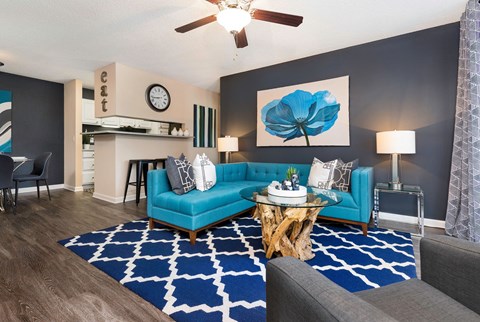 a living room with blue furniture and a blue rug
