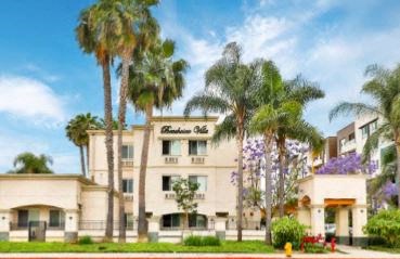 a large white building with palm trees in front of it