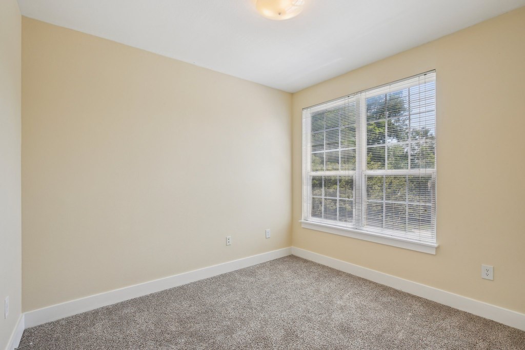 A room with a window and carpeted floor. at Province of Briarcliff Apartments, Kansas City, MO, 64118