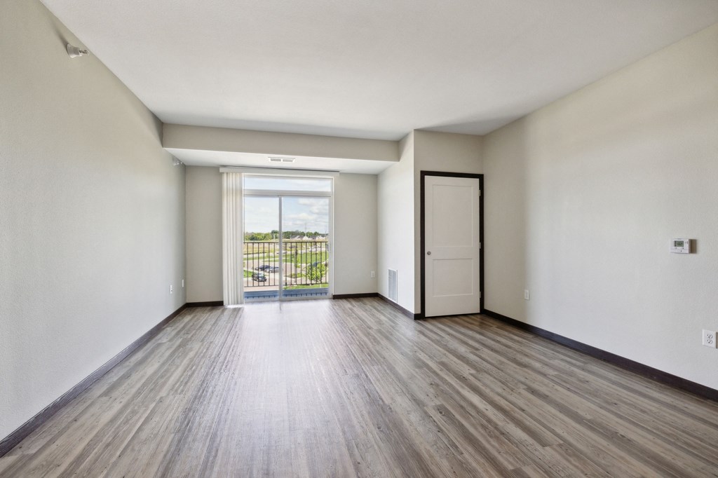 an empty living room with white walls and wood floors