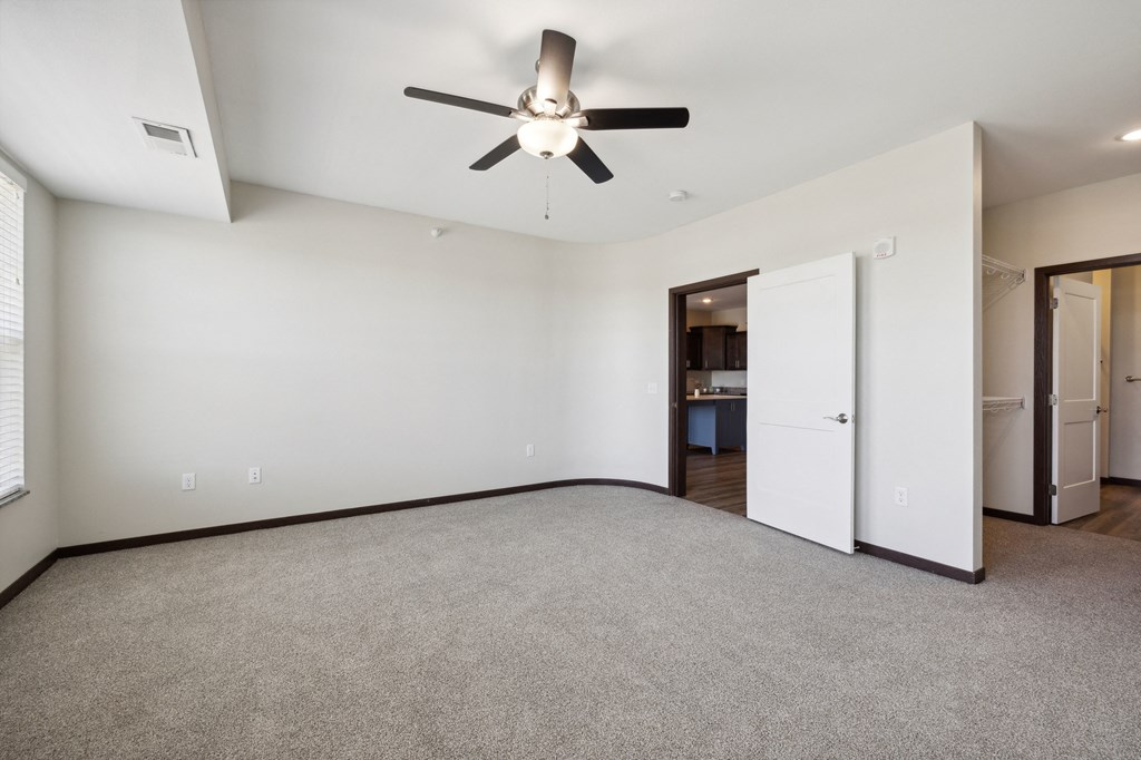 a living room with carpet and a ceiling fan
