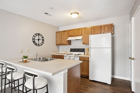 A kitchen with a white fridge and wooden cabinets.