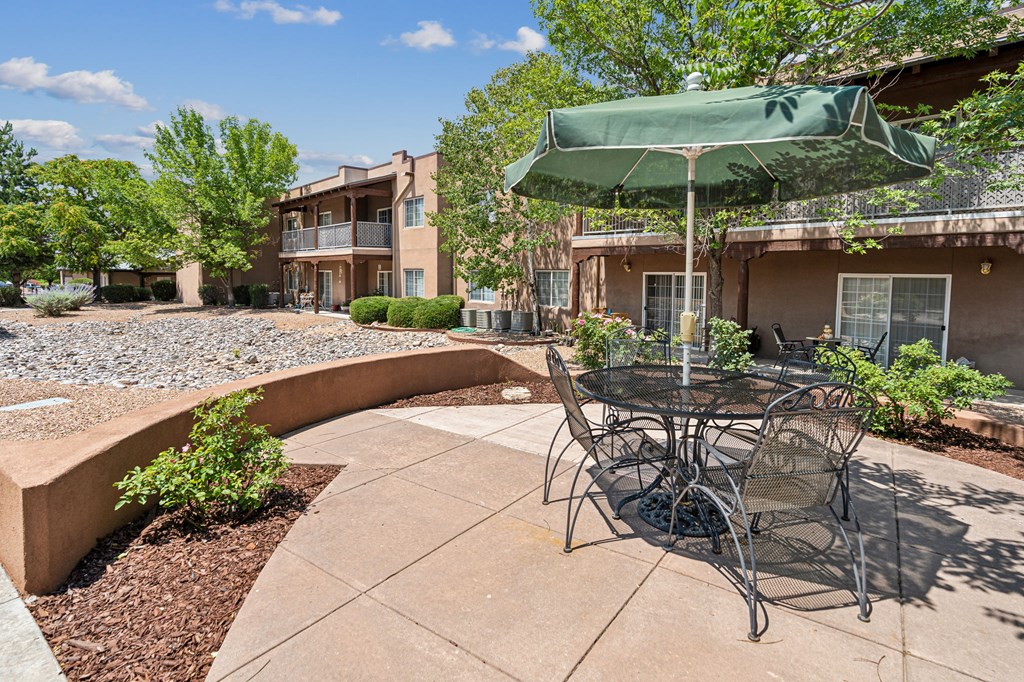 a patio with a table and chairs and an umbrella