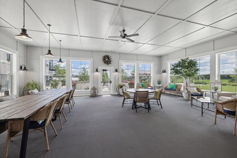 a large living room with a large table and chairs and windows