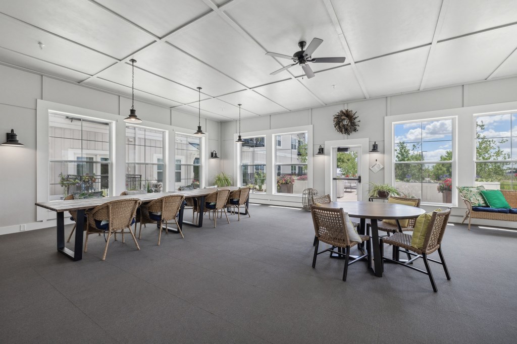 the gathering room with tables and chairs and a ceiling fan at The Hendrickson, Falcon Heights, MN