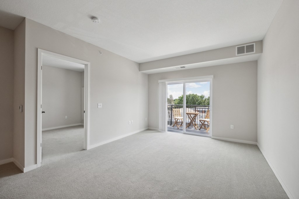 an empty living room with a door to a balcony at The Hendrickson, Falcon Heights, 55113