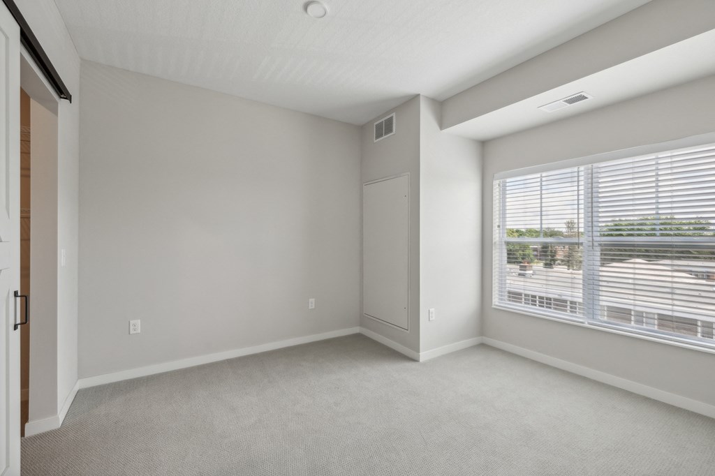 the living room of an apartment with a large window at The Hendrickson, Falcon Heights, Minnesota