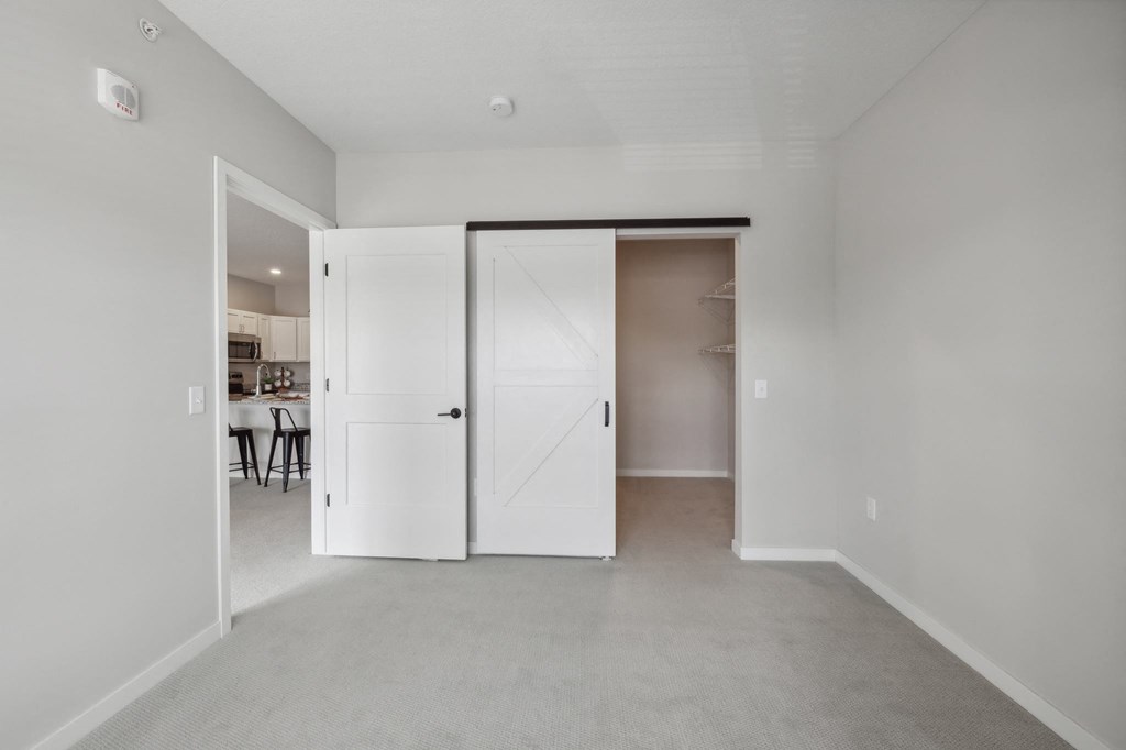 a bedroom with white walls and white closets and a carpeted floor at The Hendrickson, Minnesota, 55113