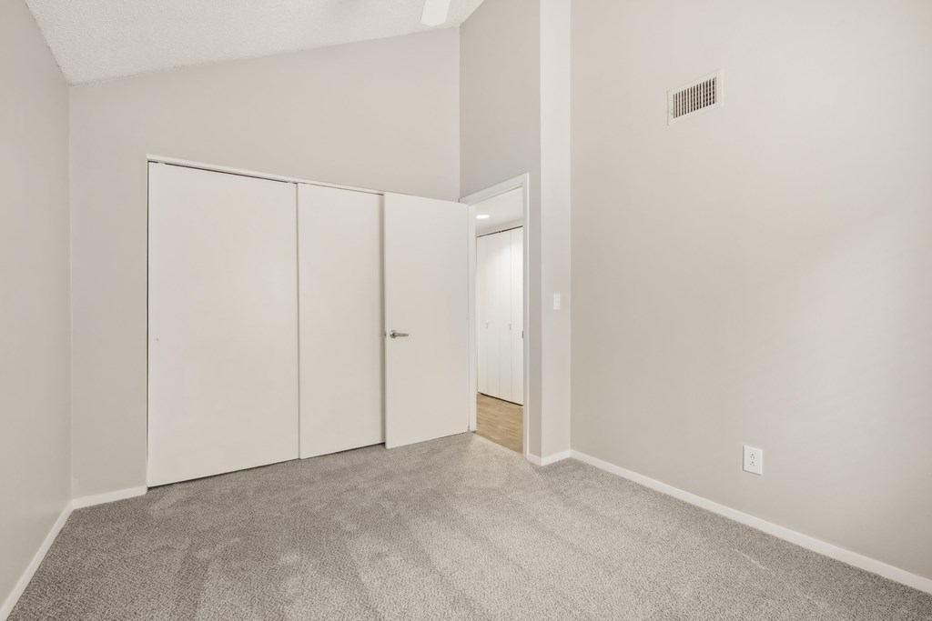 A room with a carpeted floor and a white door.