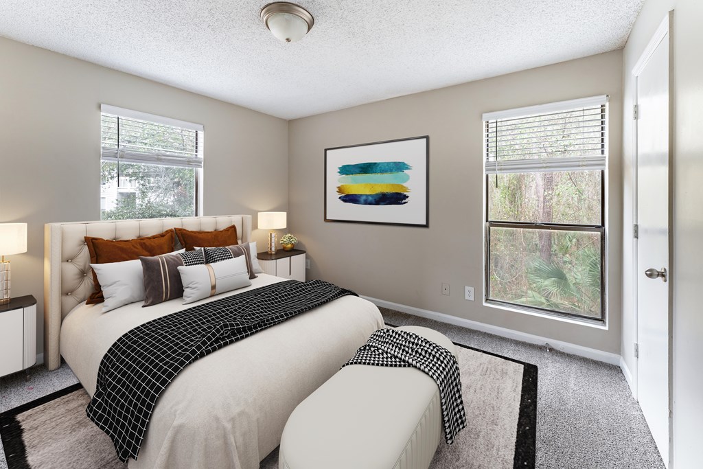 A bedroom with two beds and a painting on the wall.
