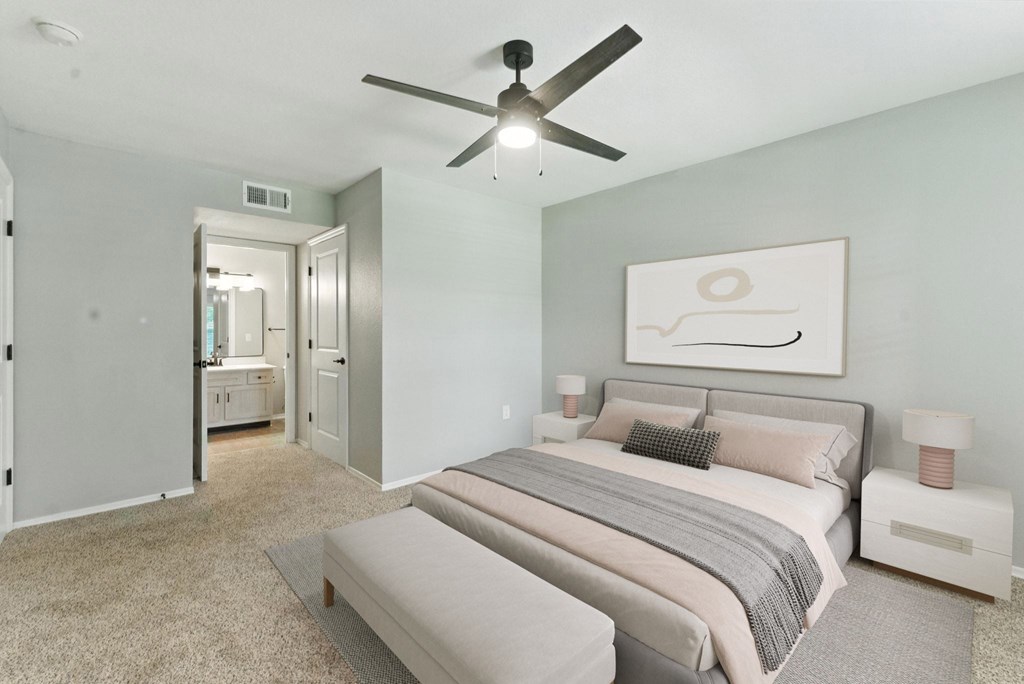 A bedroom with a large bed and a ceiling fan.