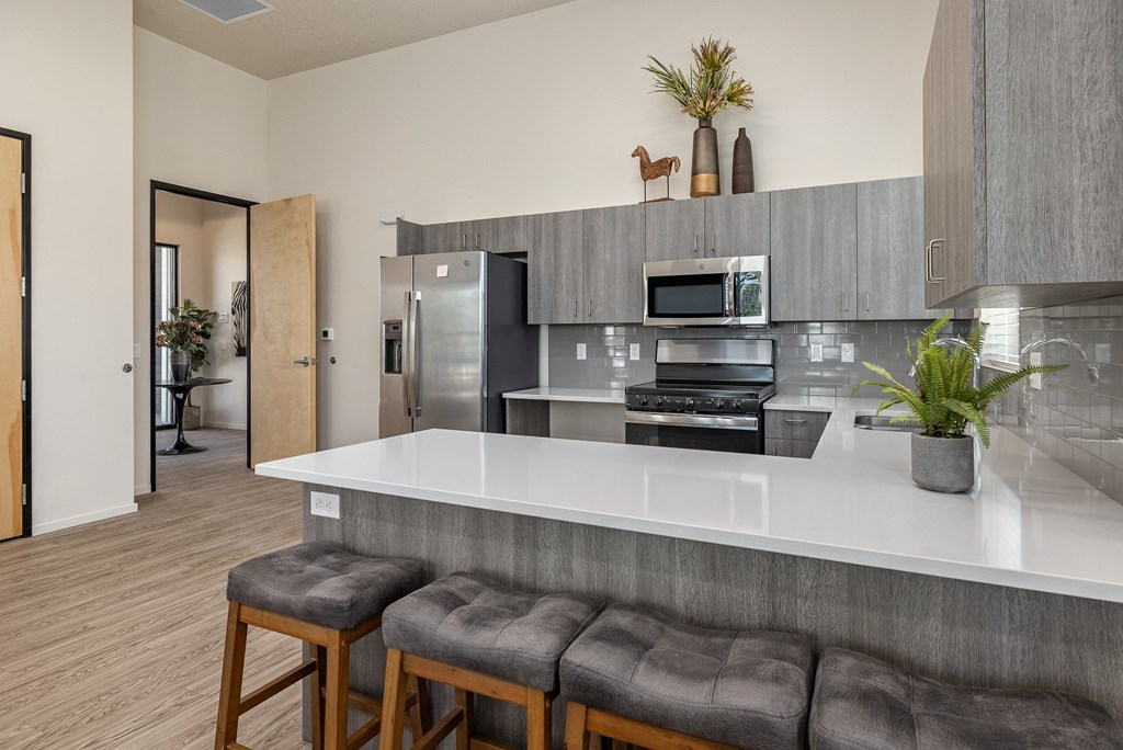 a kitchen with a white counter top and a stainless steel refrigerator