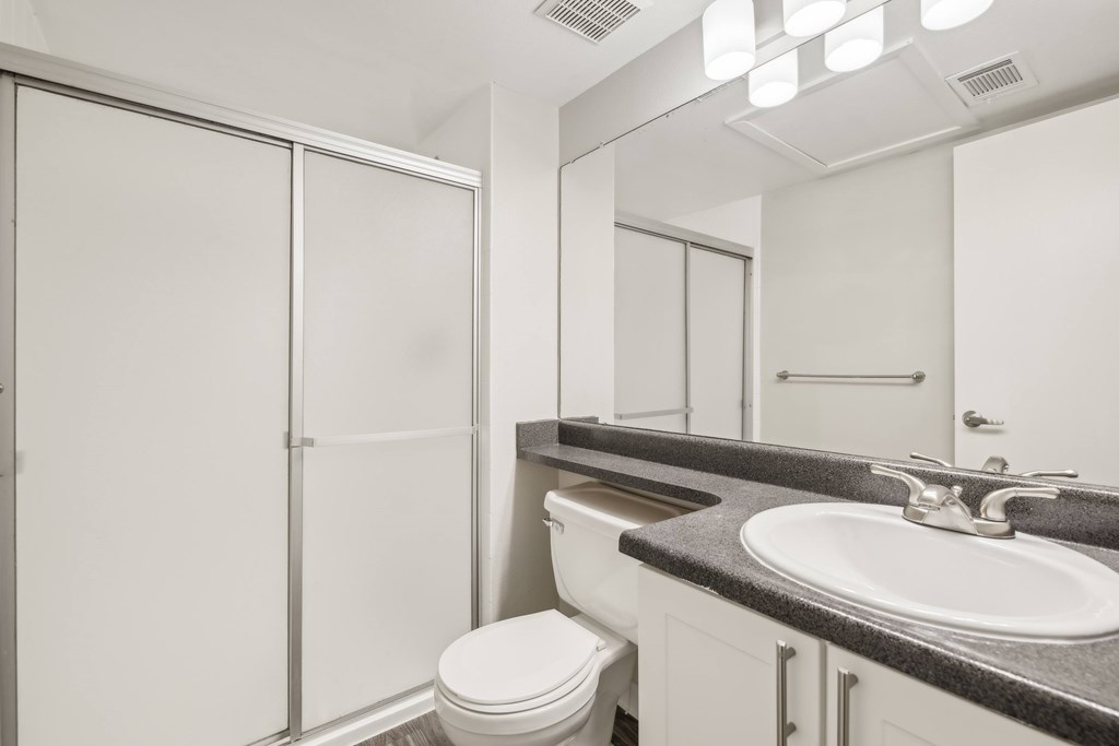 A white toilet sits next to a sink in a bathroom.