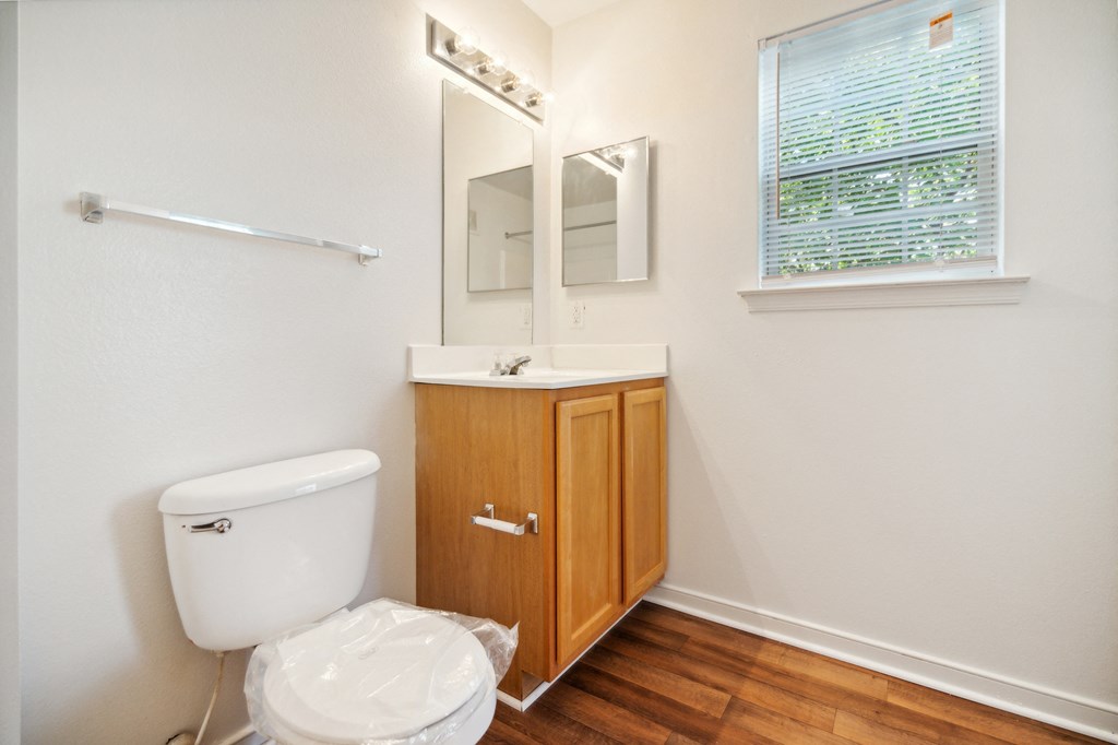 a bathroom with a toilet and a sink and a window