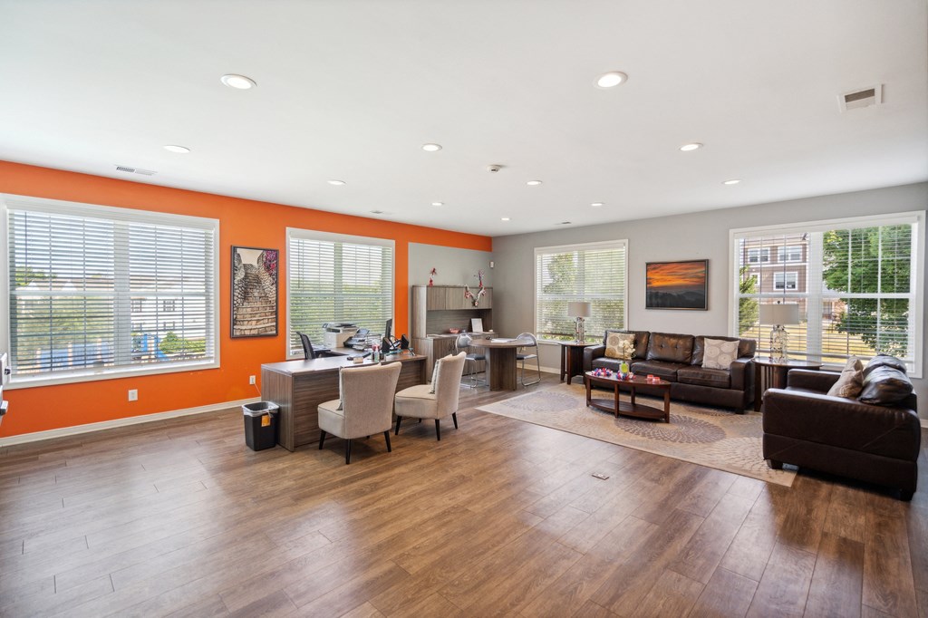 the living room and dining room of a home with wood flooring and orange walls
