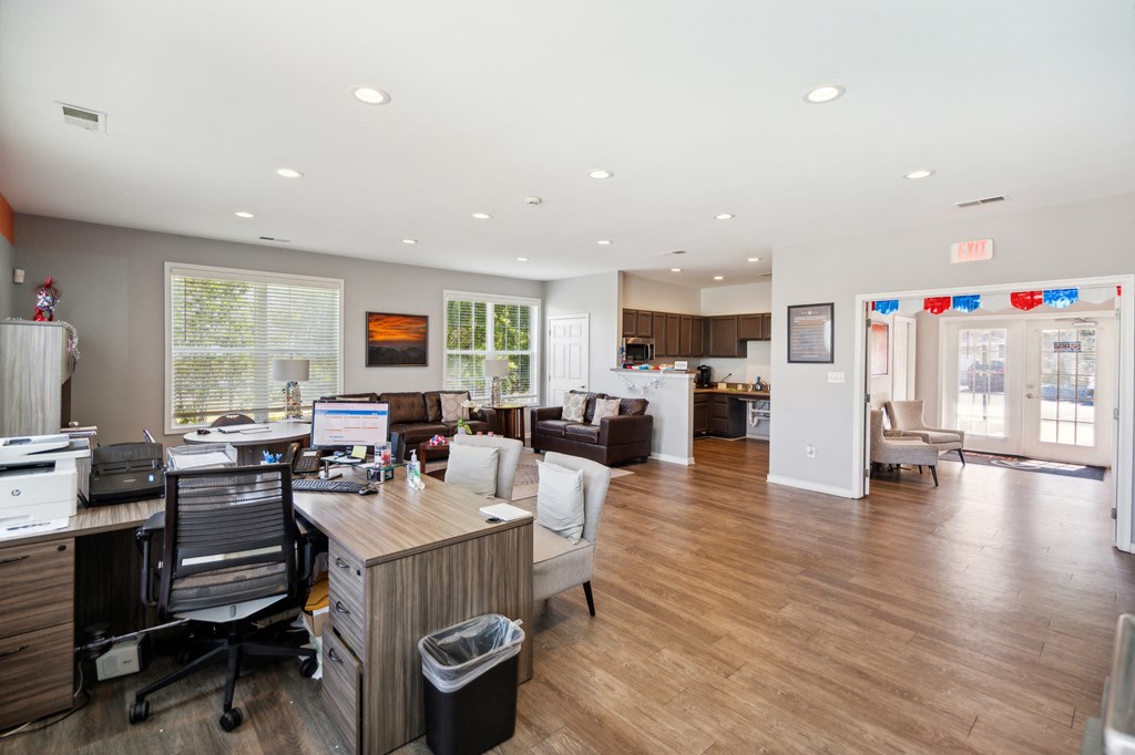 an office with a wooden floor and a desk with chairs and a computer