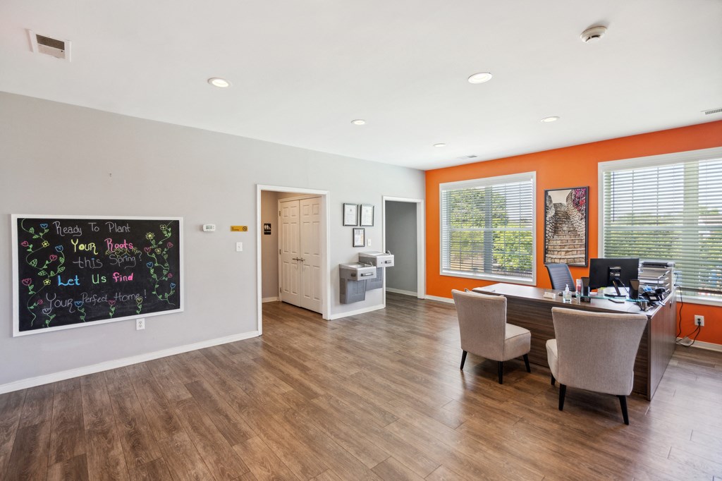 an office with a desk and chairs and a chalkboard on the wall