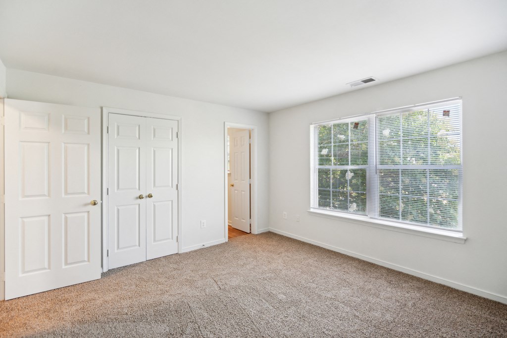 a bedroom with a large window and white doors