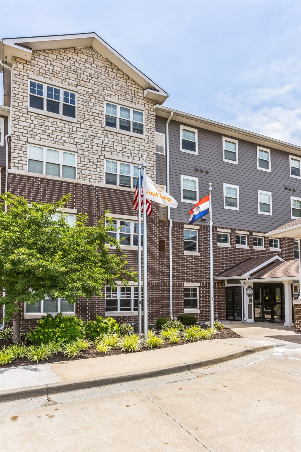 a brick building with three flags in front of it
