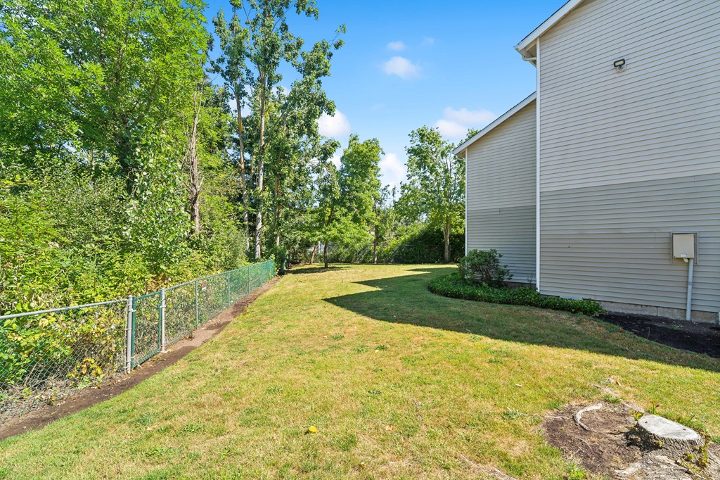 a backyard with a fence and a house