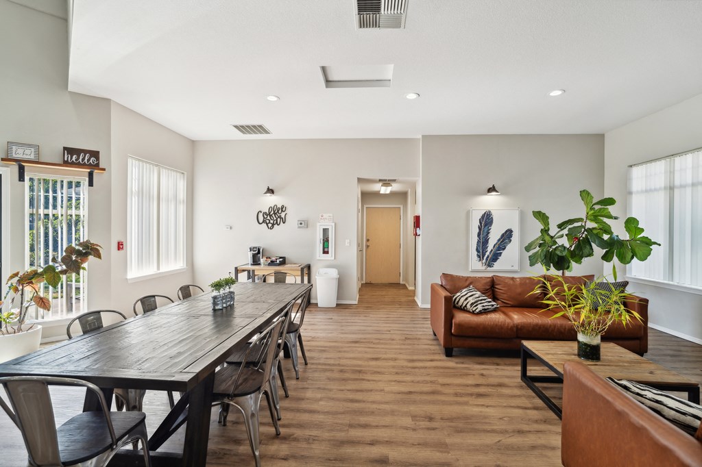 a living room and dining room with a long wooden table and chairs