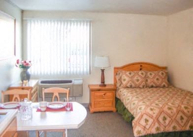 a hotel room with a bed and a desk and a table